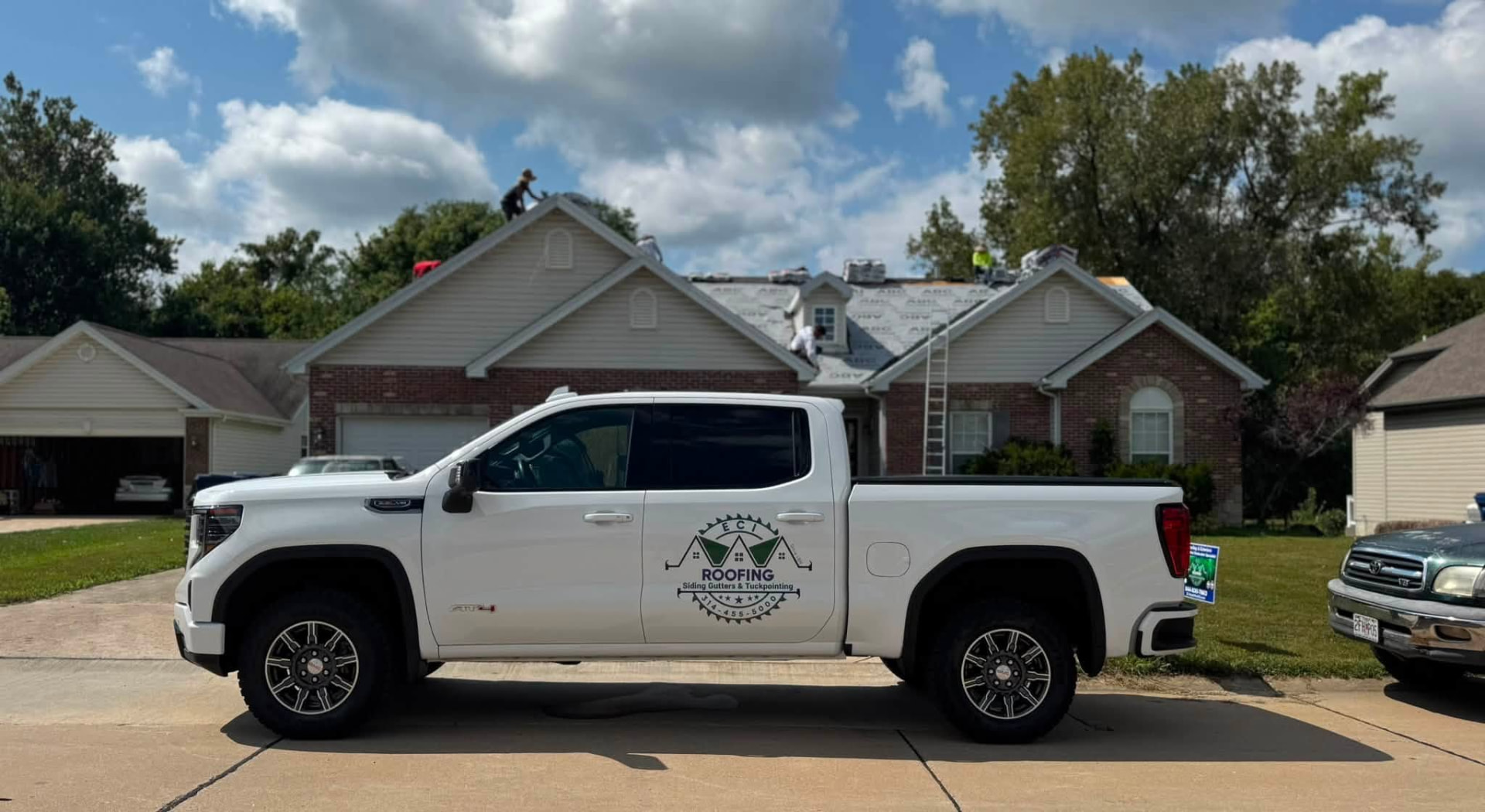 ECI truck parked at a Missouri roofing job with the crew on the roof